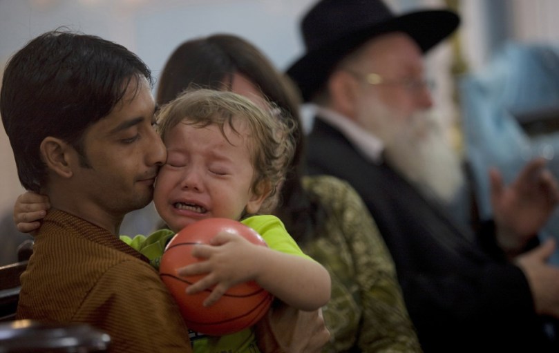Moshe Holtzberg, the 2-year-old orphan of the rabbi and his wife slain in the Mumbai Jewish center, cries during a memorial service at a synagogue in Mumbai, India, Monday, Dec. 1, 2008. Holtzberg will fly to Israel Monday on an Israeli Air Force jet with his parents' remains and the Indian woman who rescued him, an Israeli Foreign Ministry spokesman said. (AP Photo)